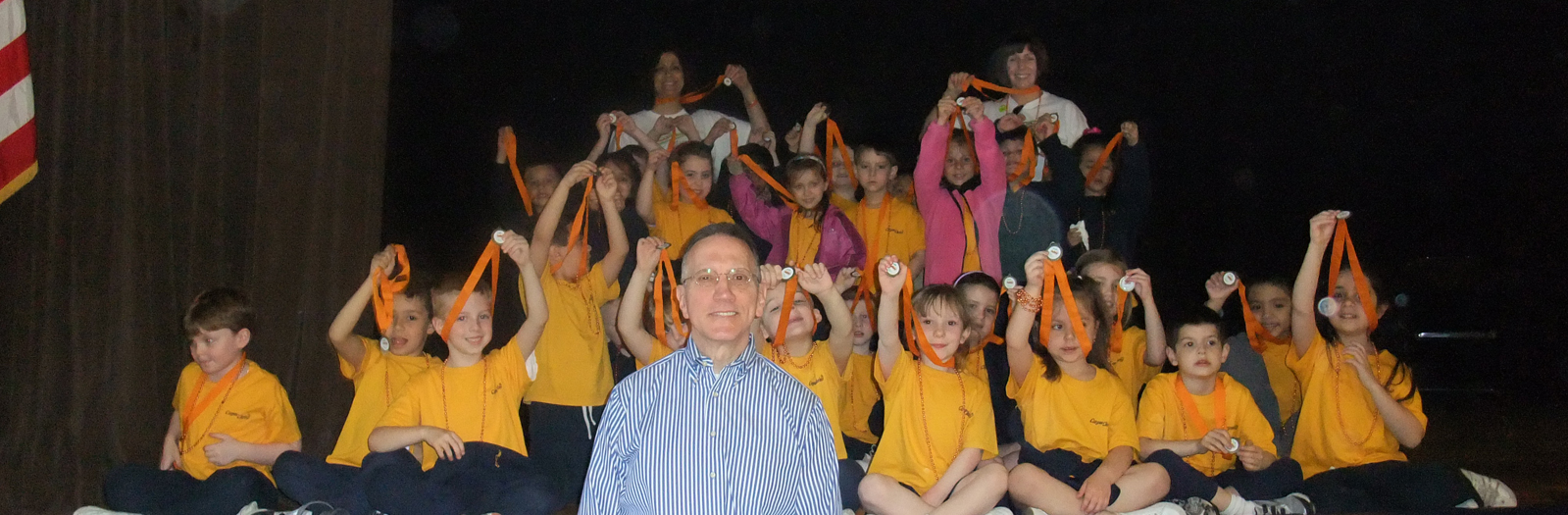 group of kids and teacher showing off their medals