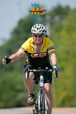 Mike biking with thumbs up